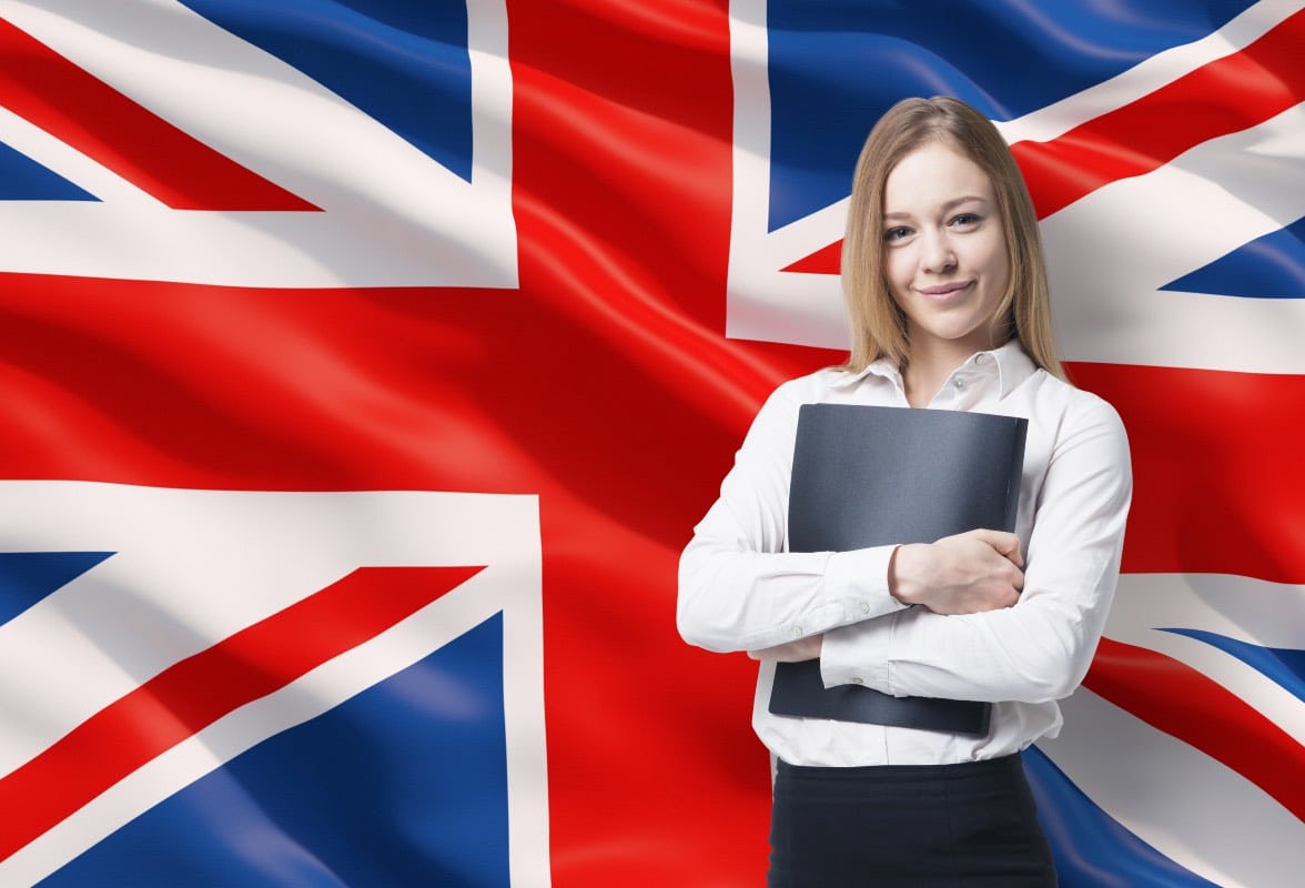 femme daffaires souriante avec le drapeau de la Grande Bretagne en arriere plan