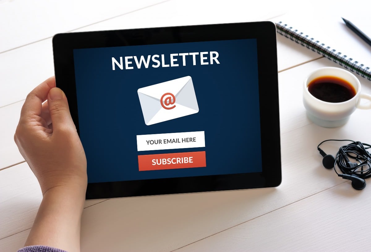 main tenant une tablette et sinscrivant a une newsletter